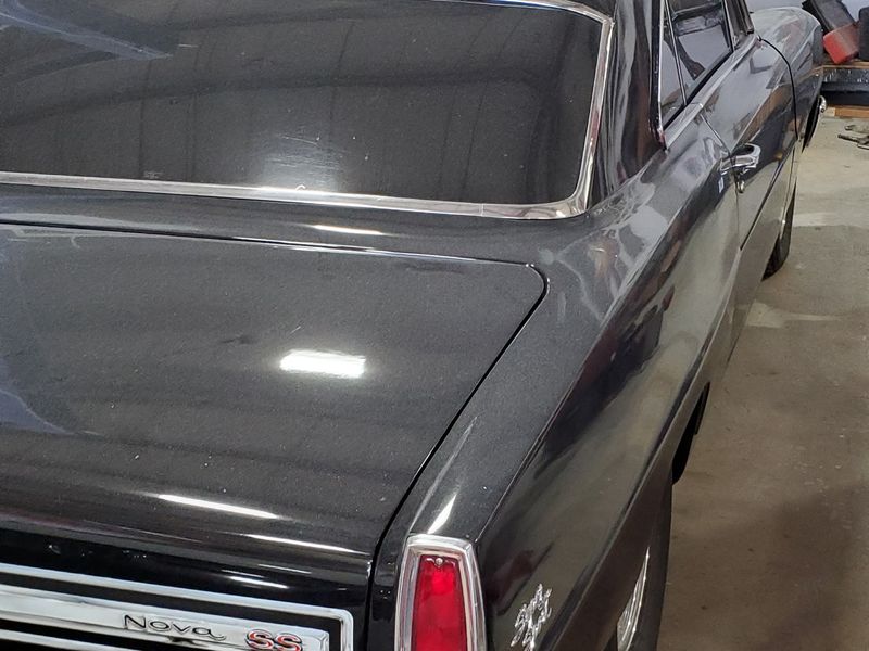 A Chevrolet Nova in the shop in its old dark paint, before a full color change.