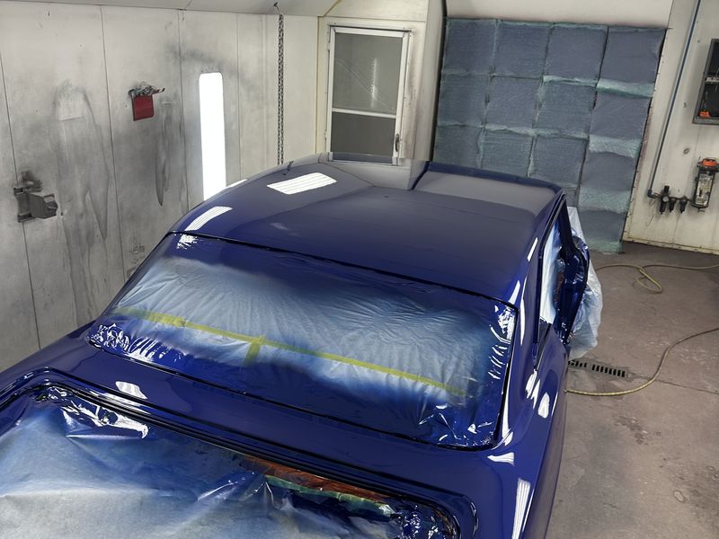 The Nova in the booth after clear coat, the blue gone deep and glossy.