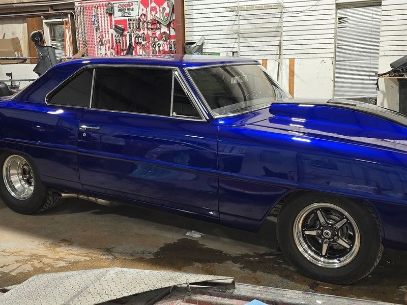 The finished Chevrolet Nova back on the shop floor in deep metallic blue.