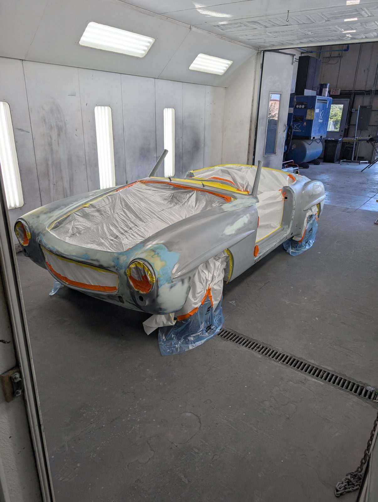 A car masked up in the shop's paint booth.