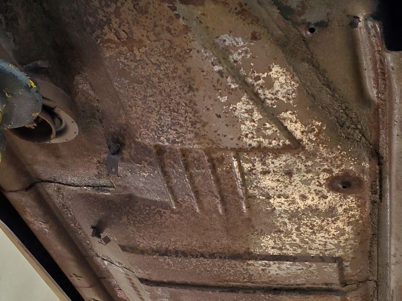 The rusted floor of a Mercedes roadster, stripped back for a full restoration.
