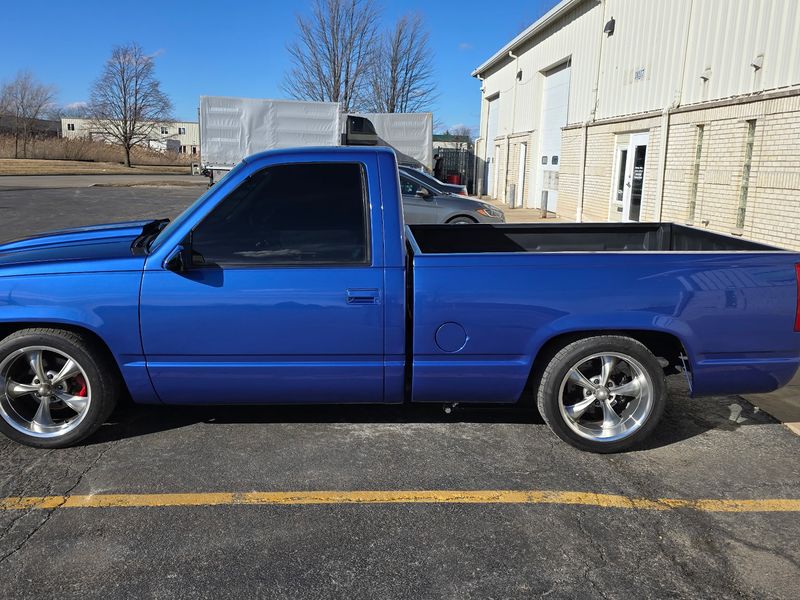 The same Chevrolet pickup outside the shop after a complete repaint in gloss blue.